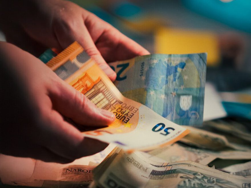 Hands counting euro banknotes and dollar banknotes